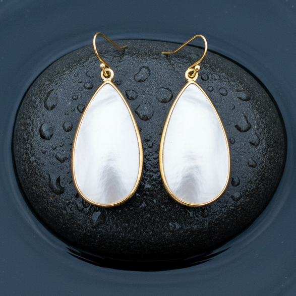 Witte parelmoeren oorbellen met goud edelstaal liggend op steen in water | Big Taerdrop White Shell Gold