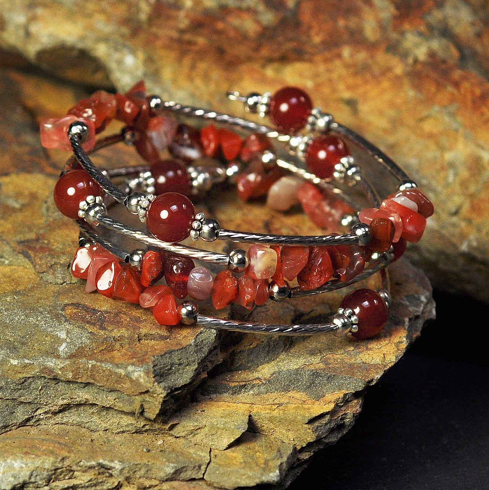 Rood edelstenen wikkelarmband met rode agaat liggend op steen | Four Loops Wrap Red Agate