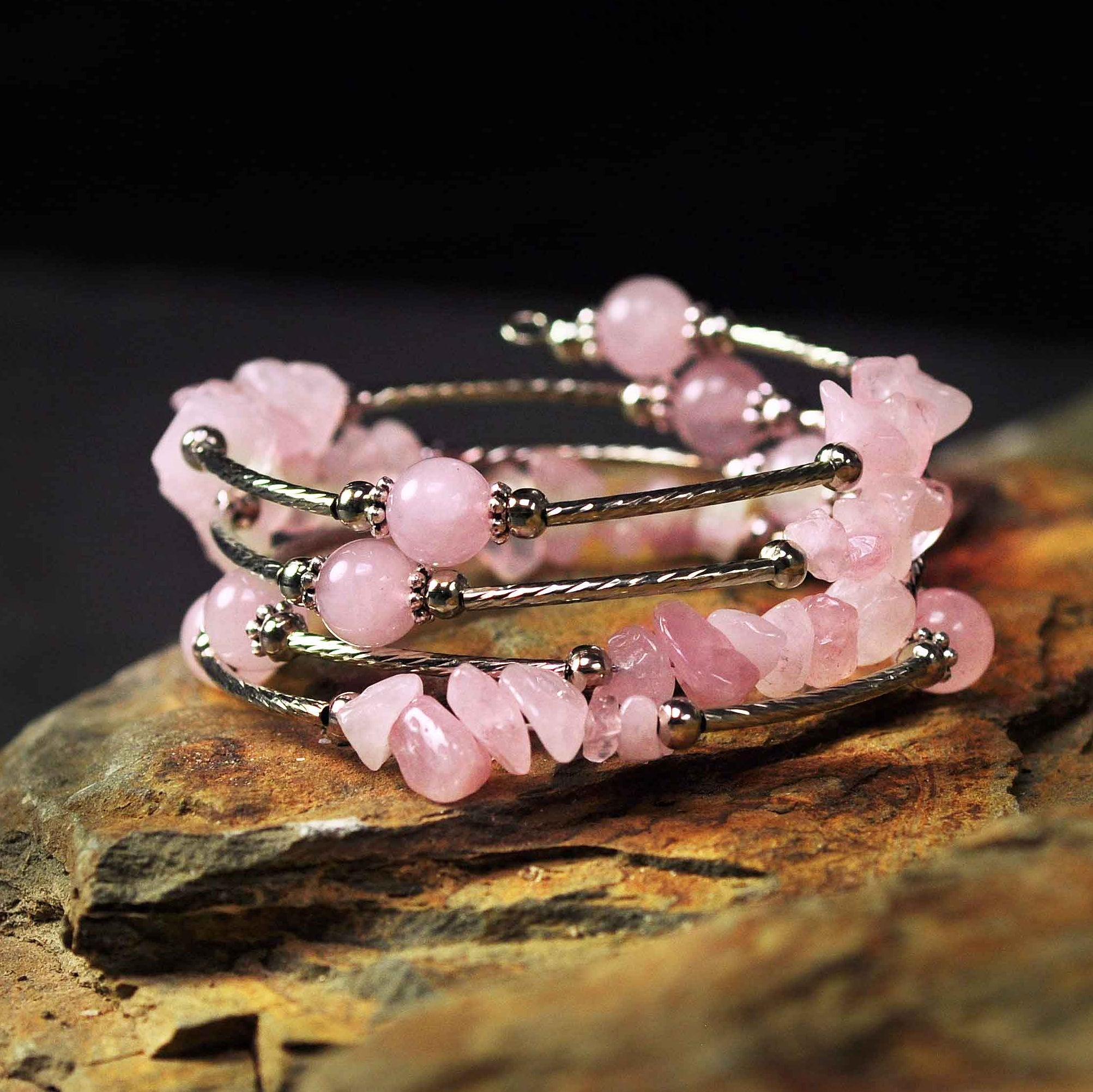 Roze edelstenen wikkelarmband met rozenkwarts liggend op steen | Four Loops Wrap Rose Quartz