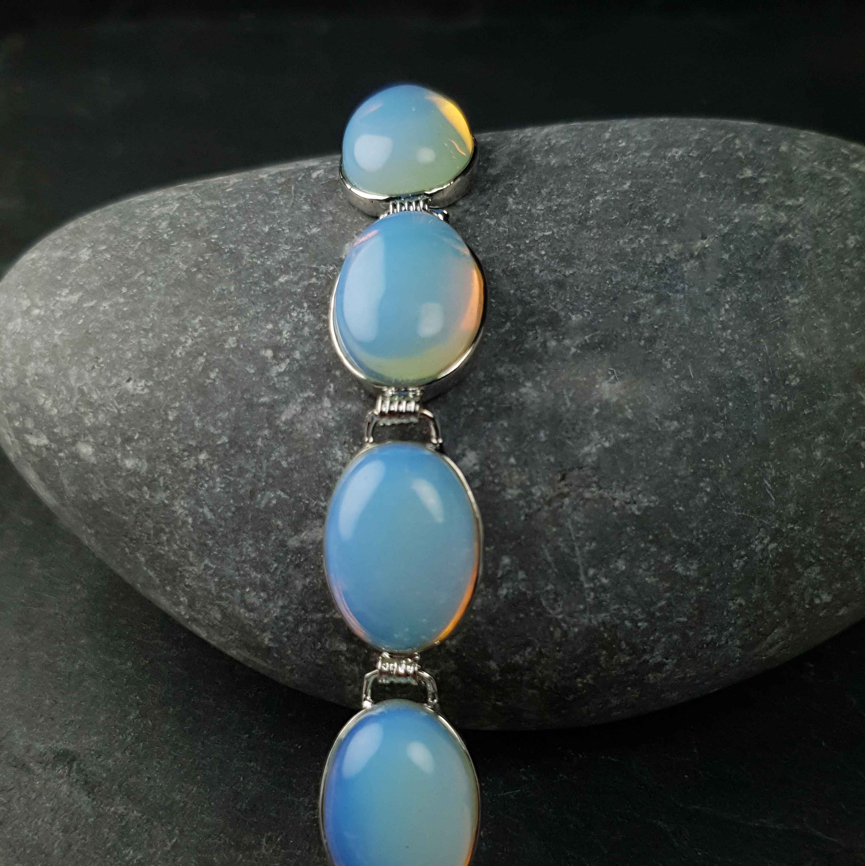 Licht blauw edelstenen armband met opaal liggend op kei | Sea Opal Oval