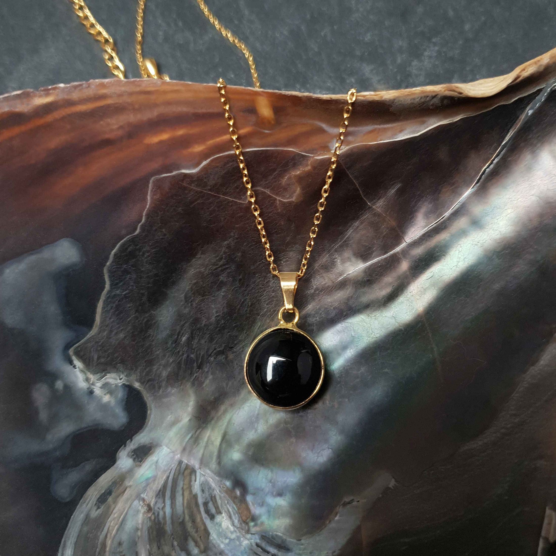 Zwarte edelstenen ketting met agaat en goud edelstaal liggend in schelp| Black Agate Gold Round