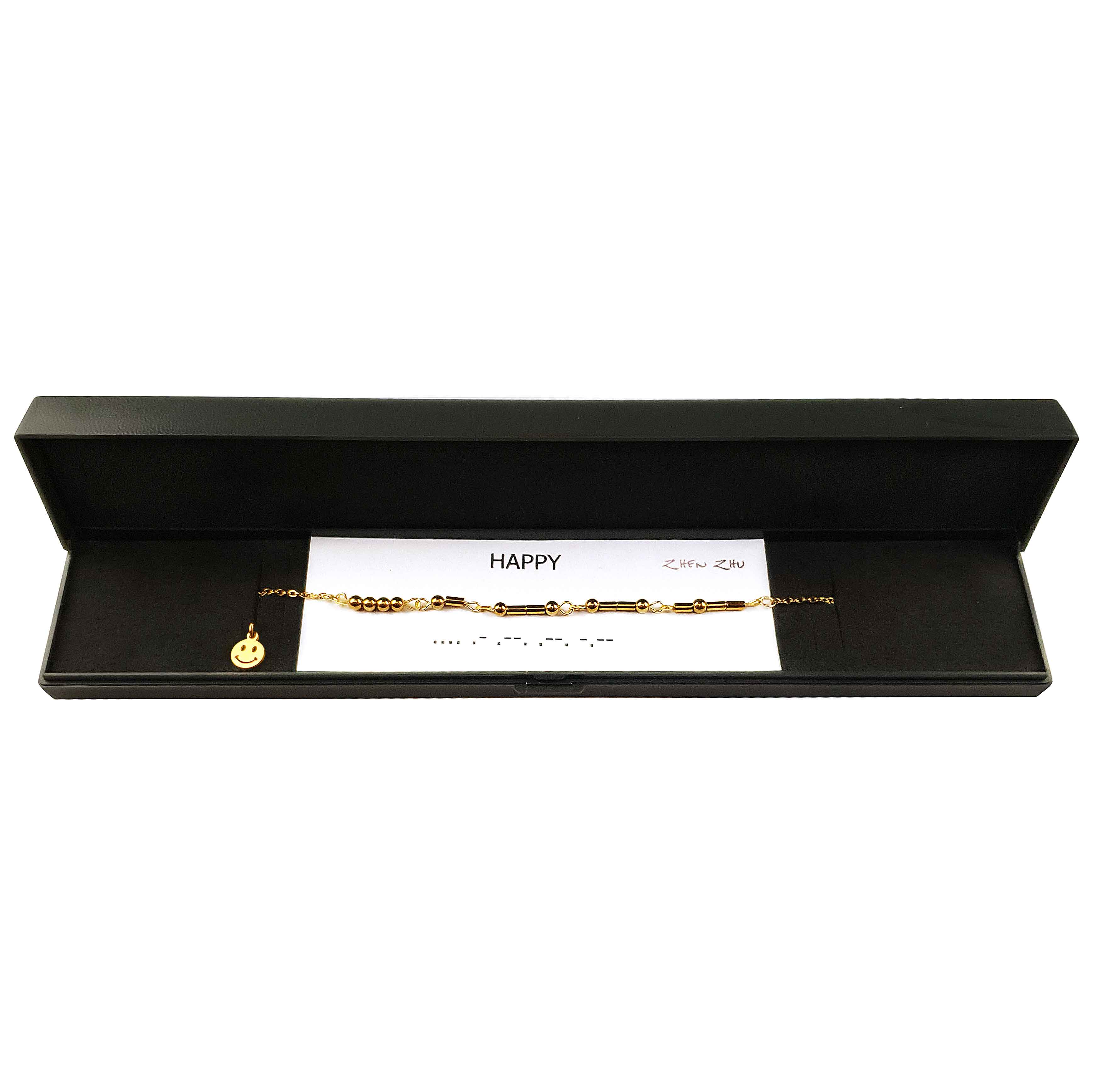 Gouden edelstenen ketting met goud edelstaal en hematiet stenen die het woord HAPPY in morse code weer geeft liggend in sieradendoosje | Morse Code Happy Gold Hematite