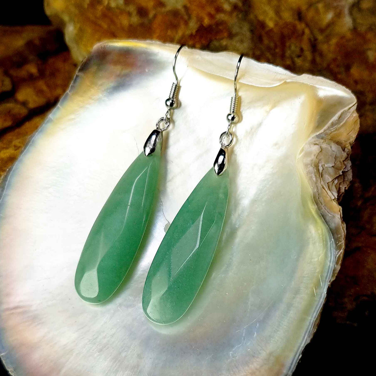 Groene edelstenen oorbellen met aventurien en sterling zilver (925) liggend in witte schelp | Big Long Drop Green Aventurine