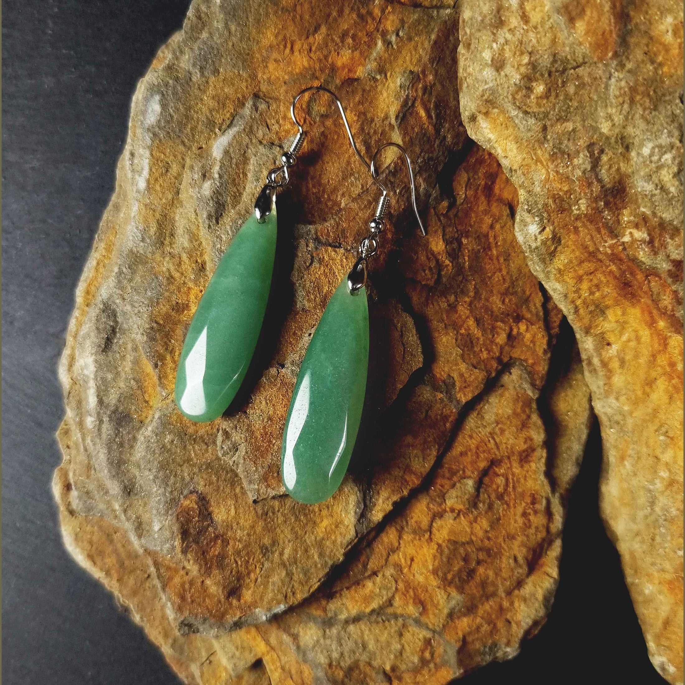 Groene edelstenen oorbellen met aventurien en sterling zilver (925) liggend op steen | Big Long Drop Green Aventurine