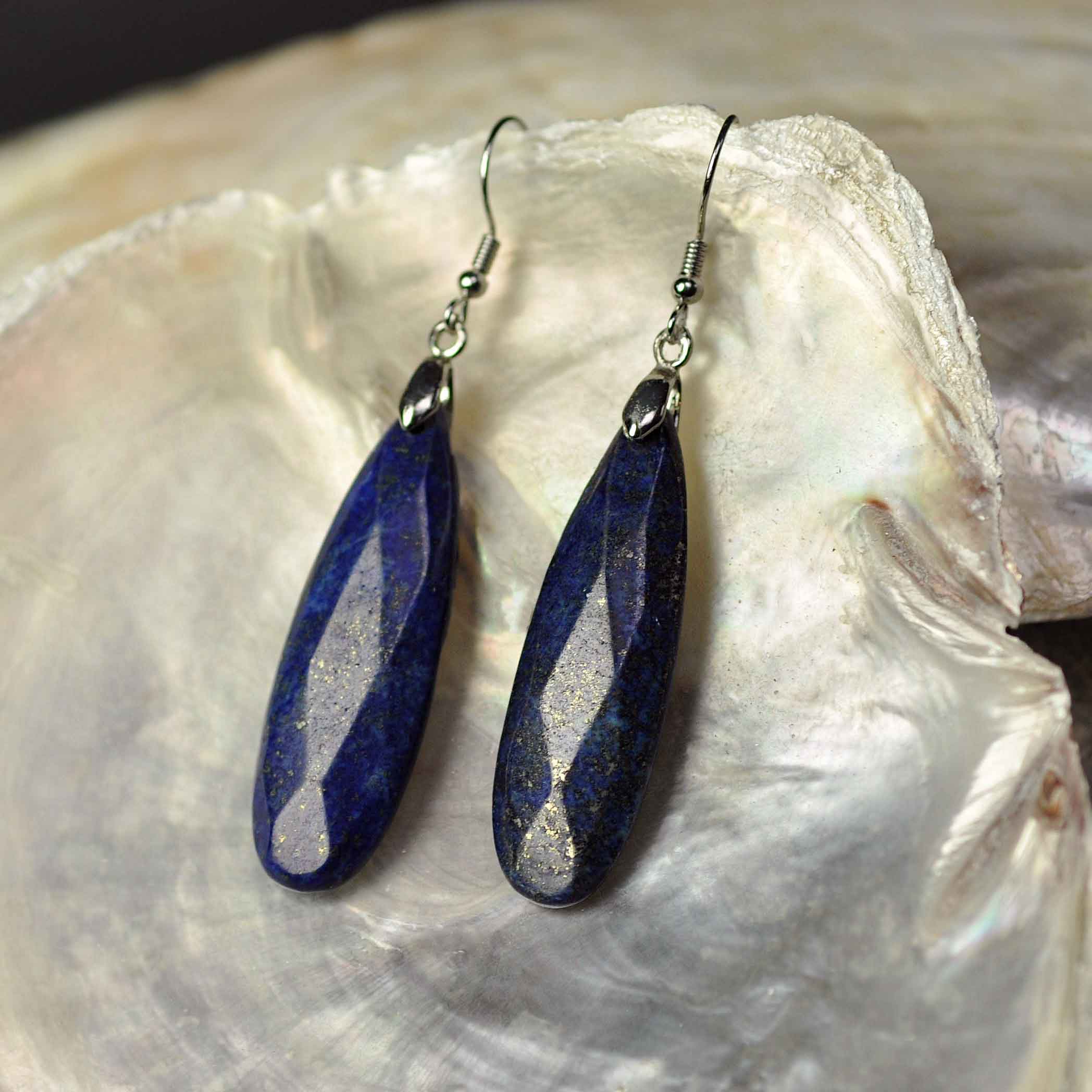 Lange blauwe edelstenen oorbellen met lapis lazuli en sterling zilver (925) liggend in witte schelp | Big Drop Lapis Lazuli