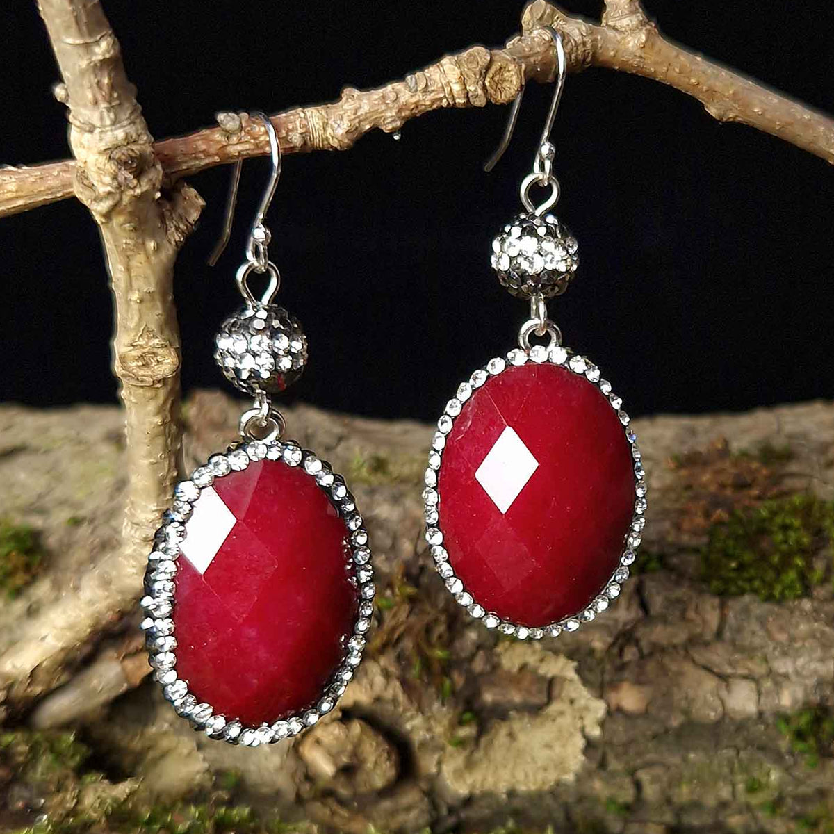 Rode edelstenen oorbellen met jade, stras steentjes en sterling zilver (925) hangend aan tak vooraanzicht | Bright Red Jade Oval