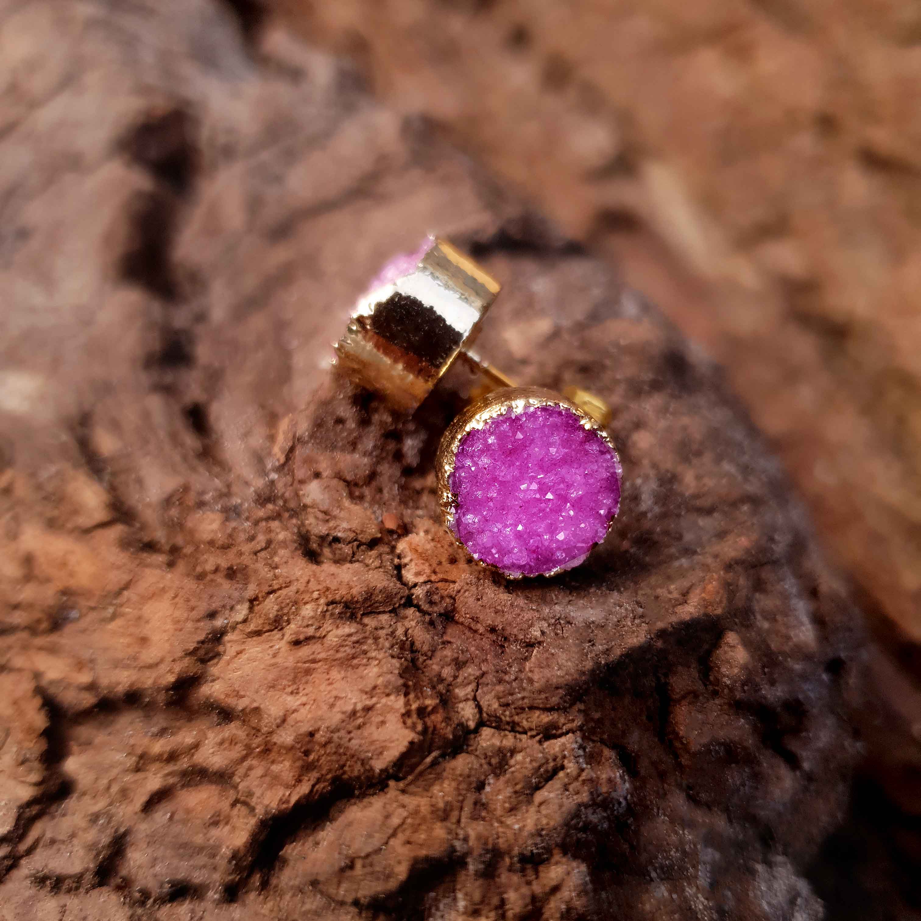 Edelstenen oorknoppen met roze druzy agaat en goud voor en zijaanzicht liggend op hout | Druzy Gold Fuchsia