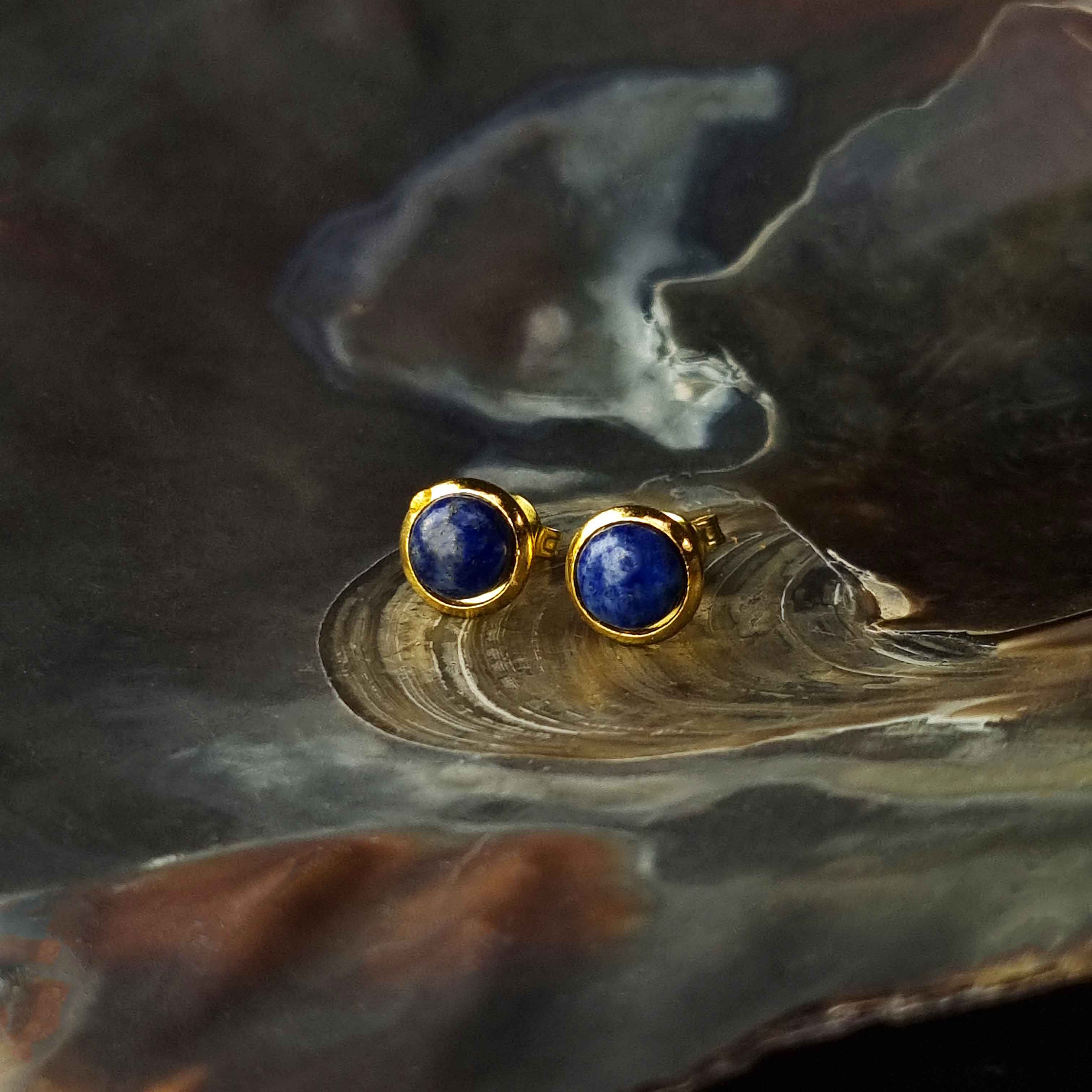 Blauwe edelstenen oorbellen met lapis lazuli, lapis lazuli oorknopjes liggend in schelp, vooraanzicht