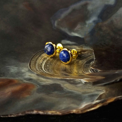 Blauwe edelstenen oorbellen met lapis lazuli, lapis lazuli oorknopjes liggend in schelp, zijaanzicht