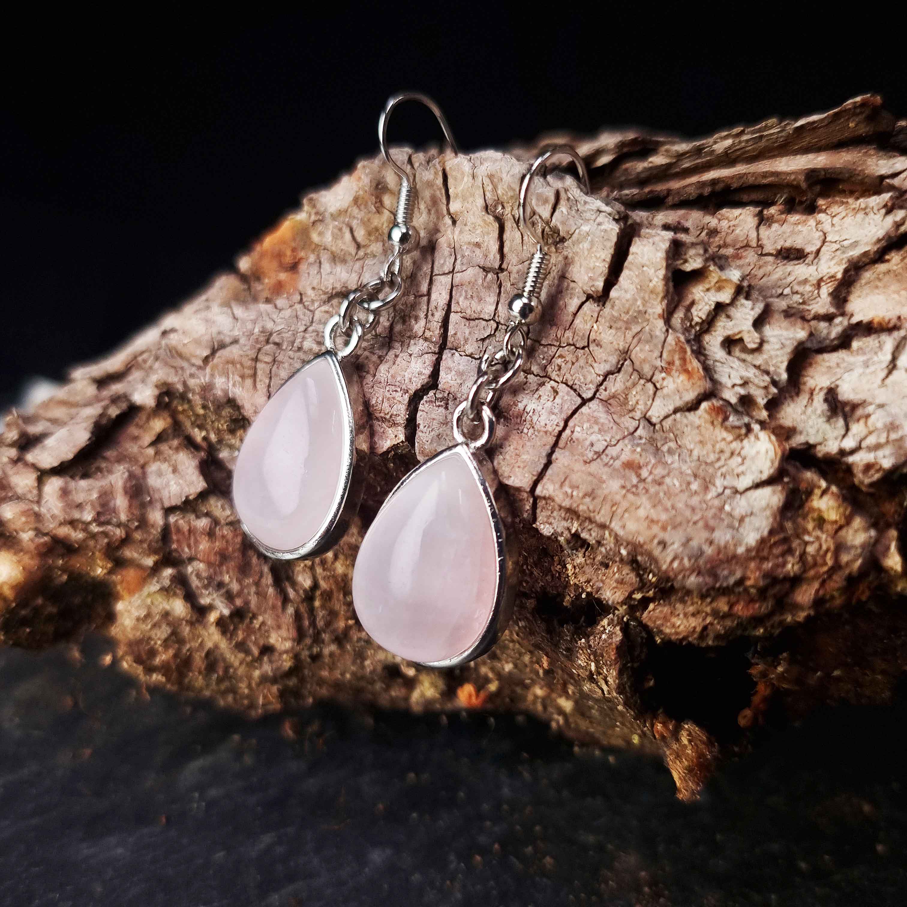 Zijaanzicht van licht roze edelstenen oorbellen met rozenkwarts en sterling zilver hangen aan schors | Rose Quartz Teardrop