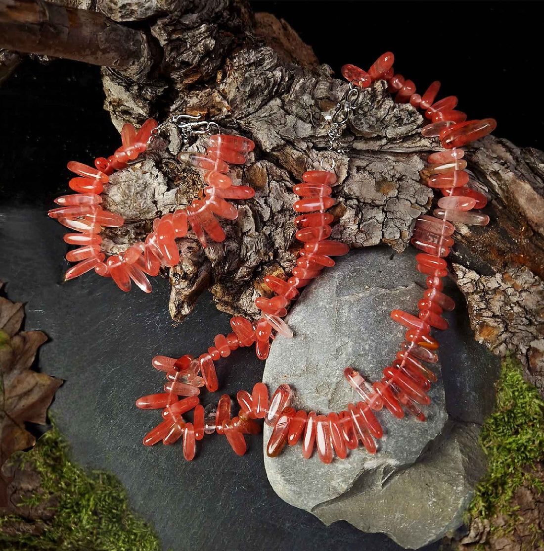 Rode edelstenen set met edelstenen ketting + edelstenen armband liggend op stronk | Cherry