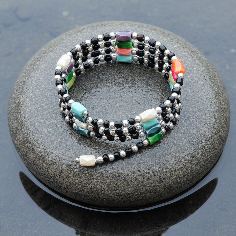 Edelstenen wikkelarmband met magnetiet liggend op steen in water| Color Black Magnetite Wrap