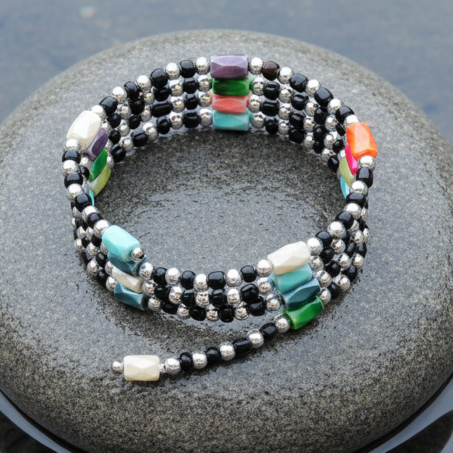 Edelstenen wikkelarmband met magnetiet liggend op steen in water| Color Black Magnetite Wrap