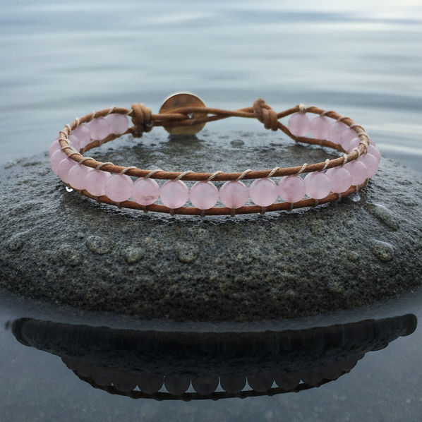 Roze edelstenen armband met rozenkwarts en licht bruin leer liggend op steen | Wrap Rose Quartz Light