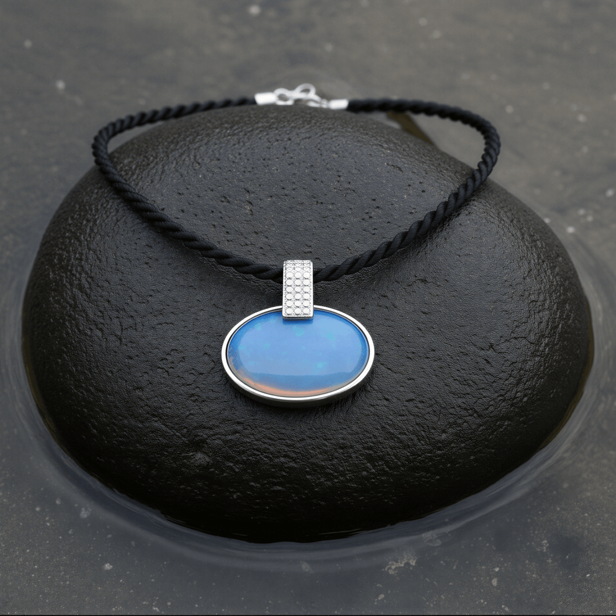 Blauwe edelstenen ketting met zee opaal liggend op steen in water | Nadja
