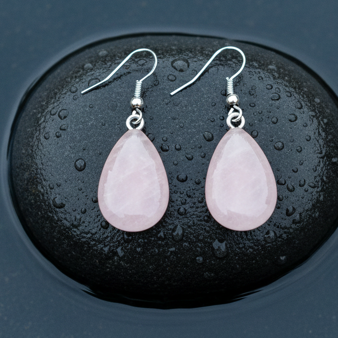 Roze edelstenen oorbellen met rozenkwarts in druppel vorm en sterling zilver (925) liggend op steen in water| Rosé Quartz Drop