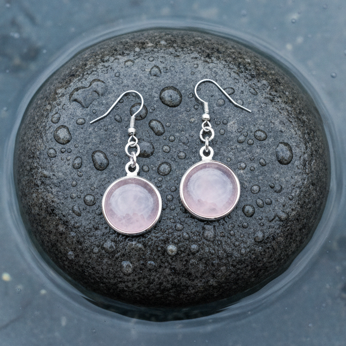 Roze edelstenen oorbellen met rozenkwarts en sterling zilveren oorbelhaakjes, rozenkwarts oorhangers liggend op steen in water | rosé Quartz Round