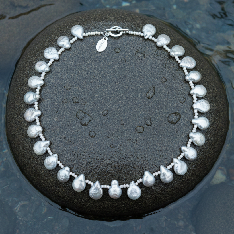 Zoetwater parelketting met grijze parels liggend op steen in water | Little Grey Coin
