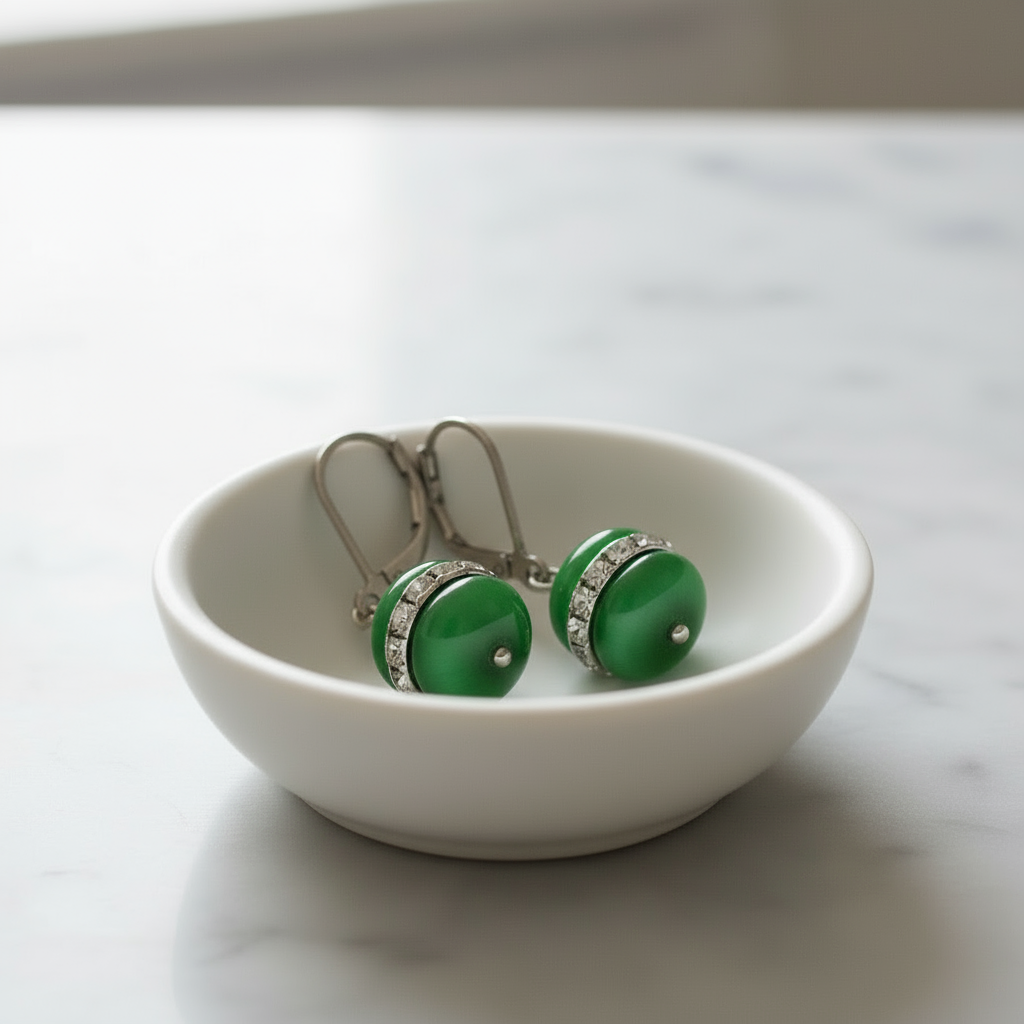 Groene edelstenen oorbellen met kattenoog en sterling zilver liggend in schaaltje