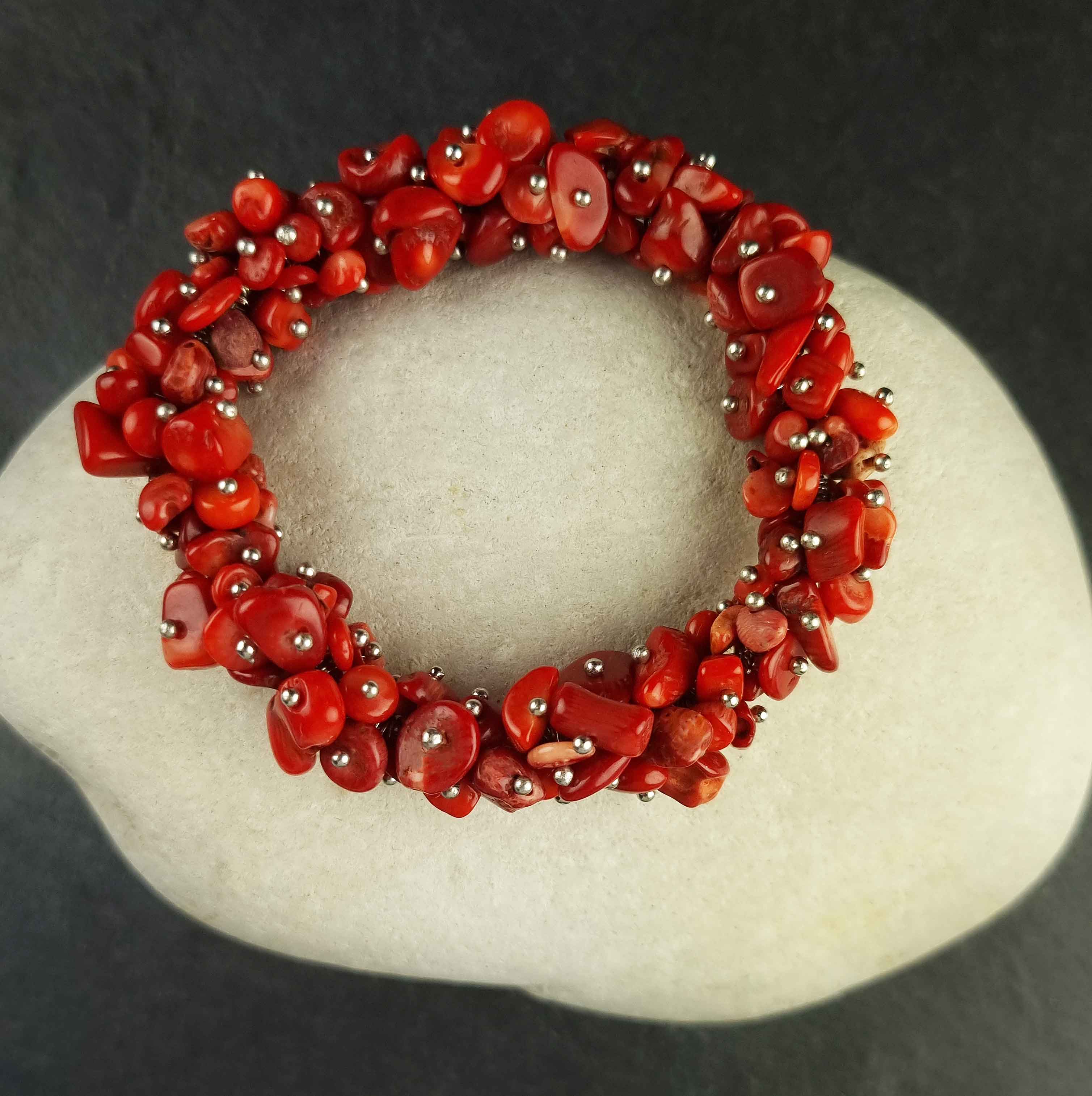 Dik rood koralen armband met stukjes koraal liggend op witte kei | Coral Chip