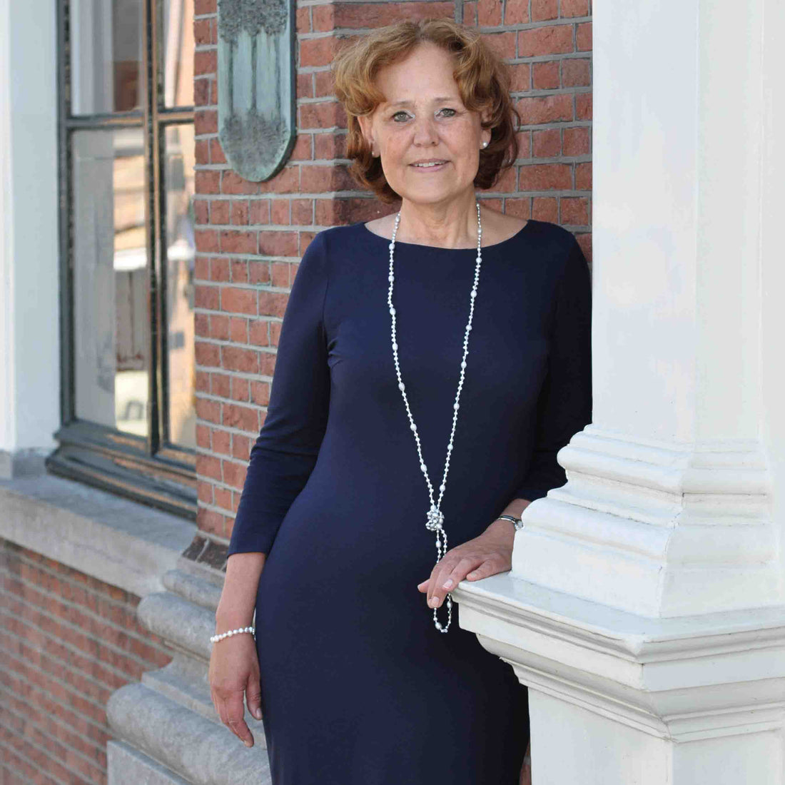 Lange zoetwater parelketting met grijze parels op model tegen muur | Long Seed Bead Grey