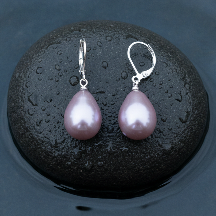 Roze mother of pearl parel oorbellen met zilver edelstaal liggend op steen in water | Holly