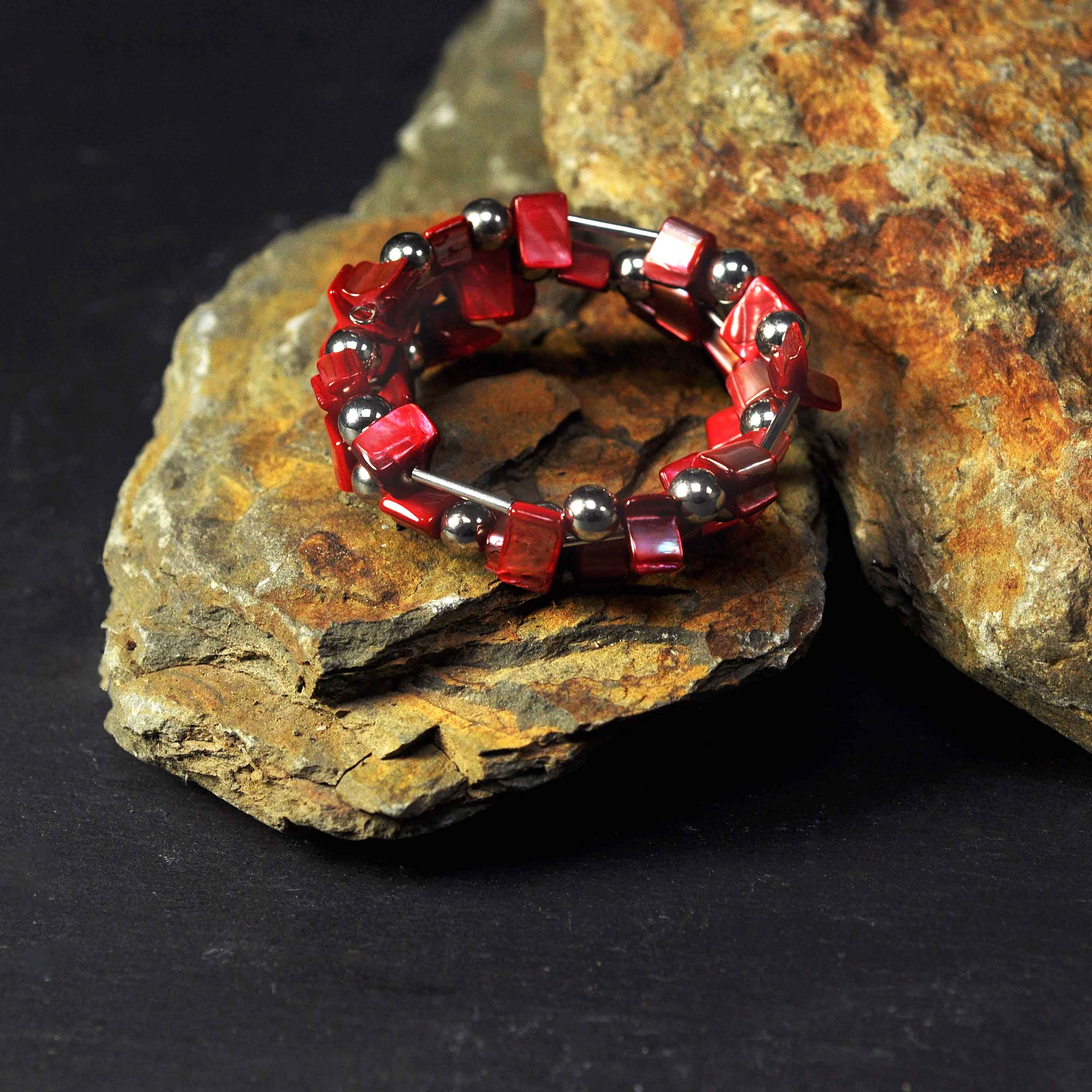 Rood parelmoeren wikkelarmband liggend op steen | Wrap Shell Red