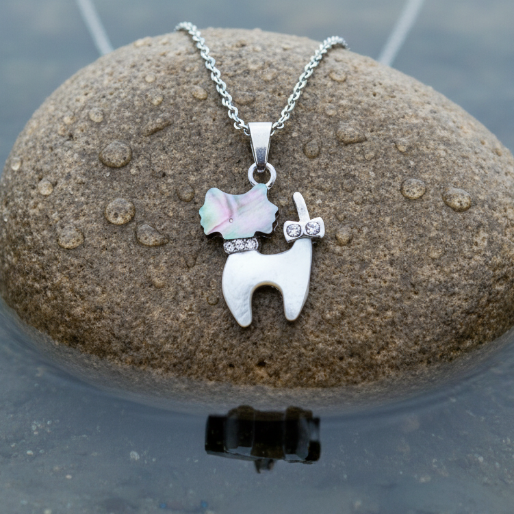 Parelmoeren ketting met parelmoeren hanger met stras steentjes in de vorm van een kat met zilver edelstaal liggend op steen vooraanzicht | Shell Cat