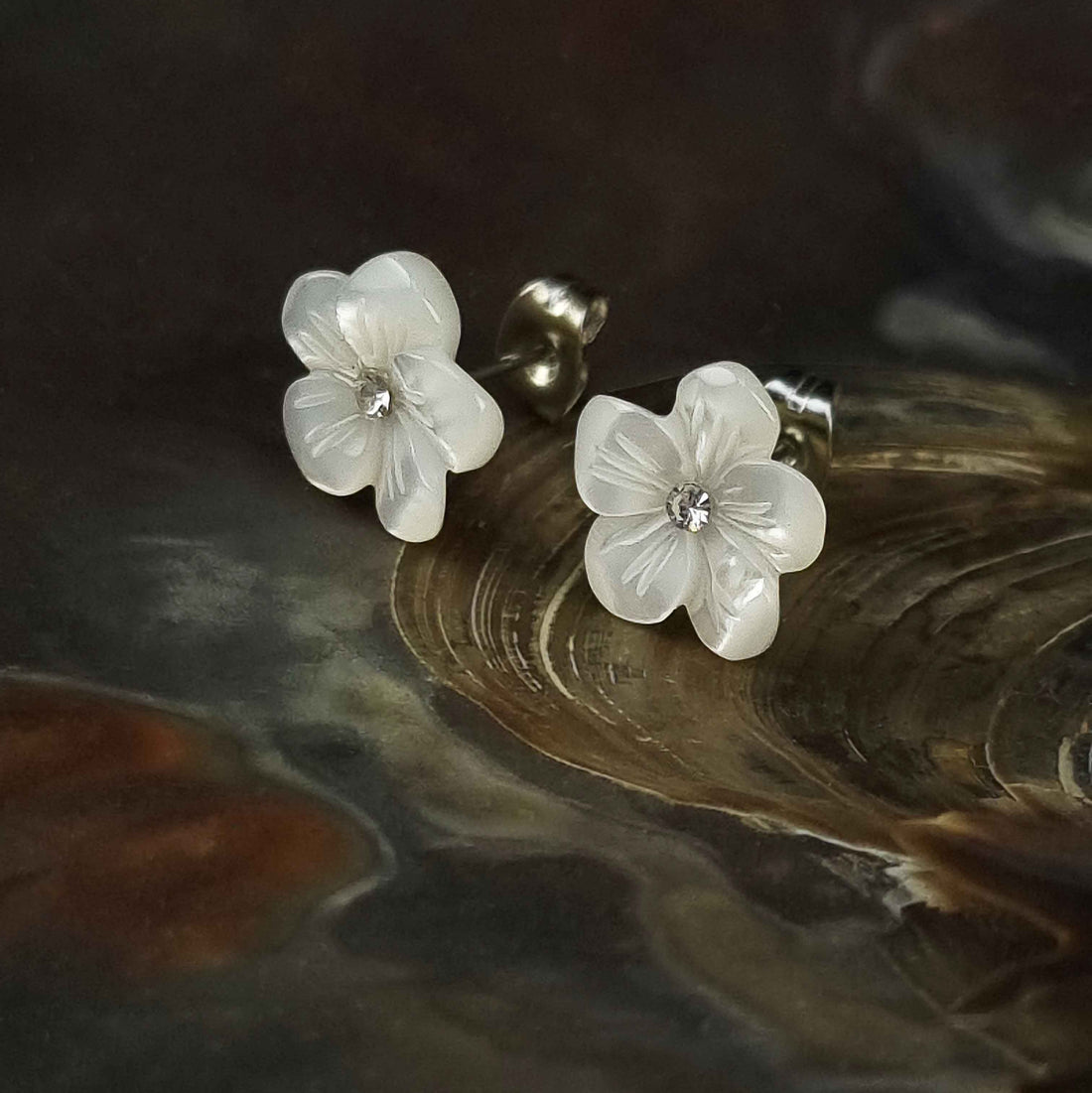 Witte parelmoeren oorknopjes met bloem en stras steentje liggend in schelp | Big Flower Bling