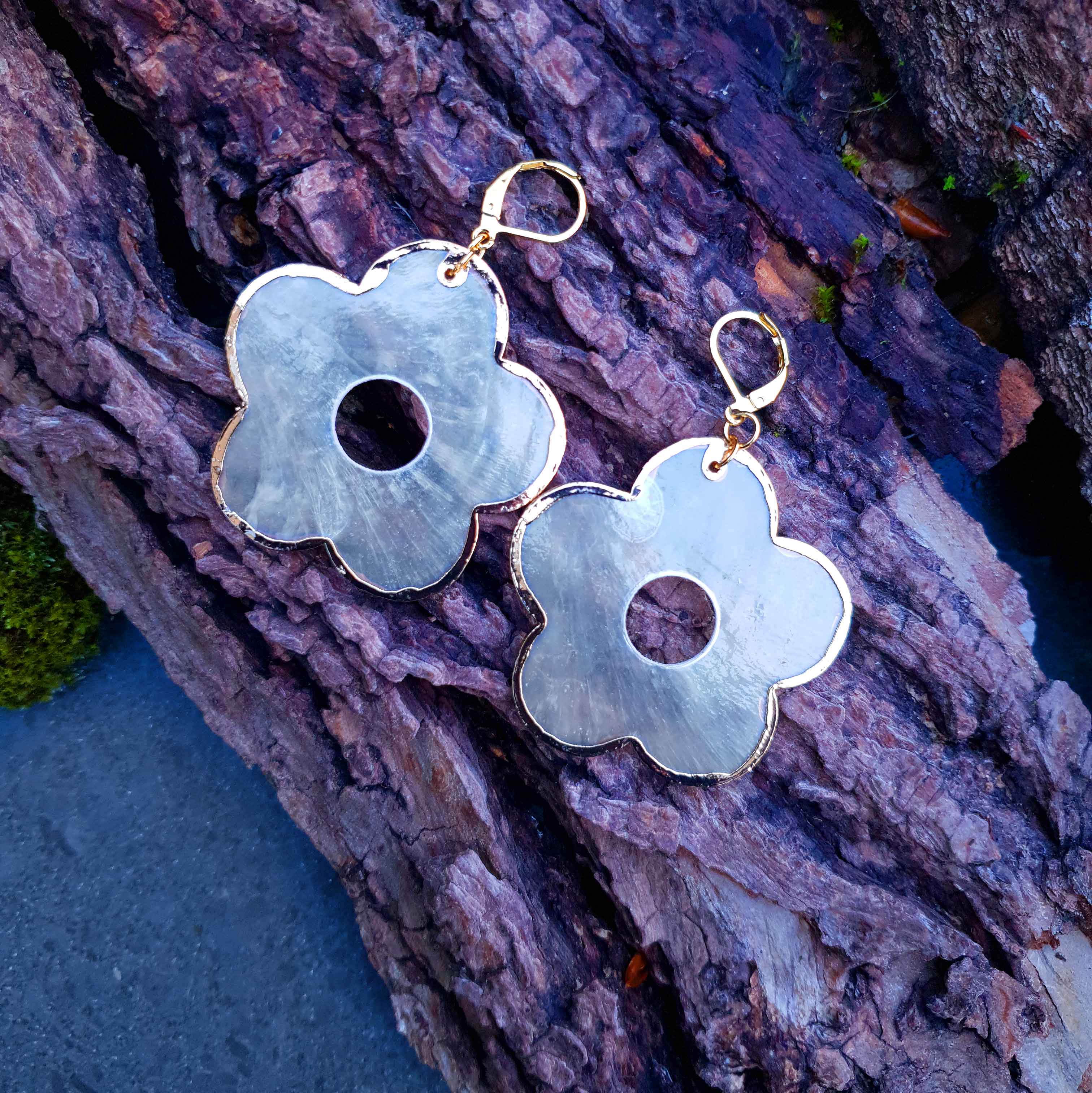 Parelmoeren oorbellen met grote bloem en goud kleurig edelstaal liggend op hout | Capiz Shell Gold