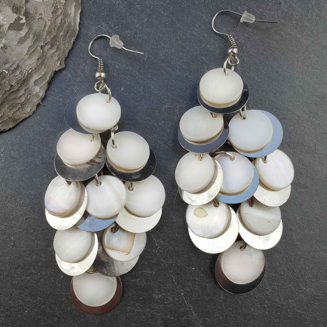 Lange witte parelmoeren oorbellen met sterling zilver 925 liggend op leisteen | White Shell Circles