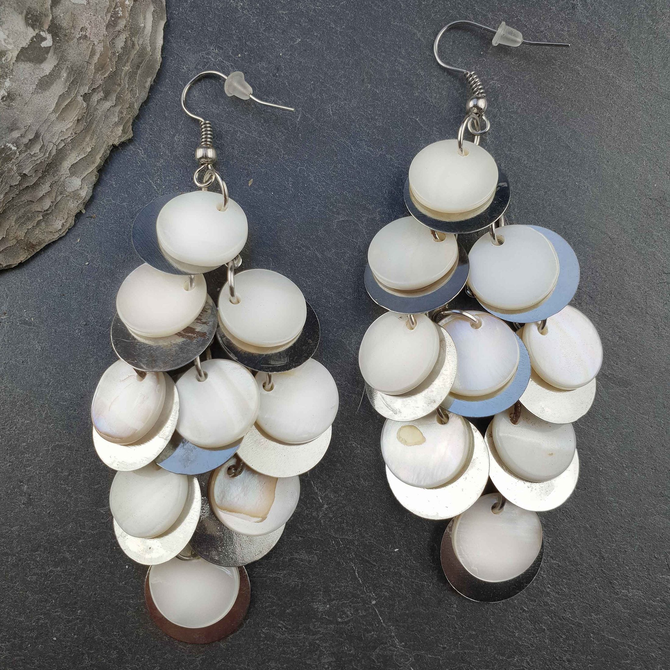 Lange witte parelmoeren oorbellen met sterling zilver 925 liggend op leisteen | White Shell Circles