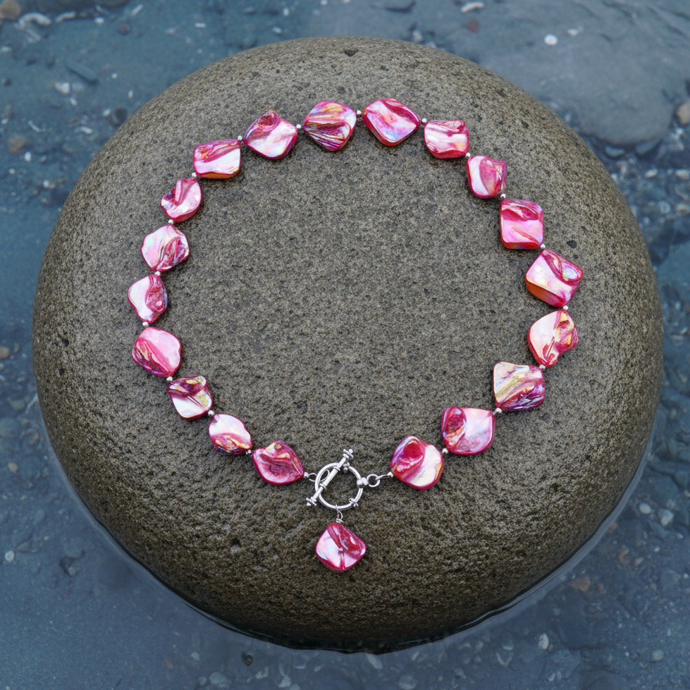 Pink gekleurde parelmoeren schelpen ketting met hanger liggend op steen | Shell AB Pink