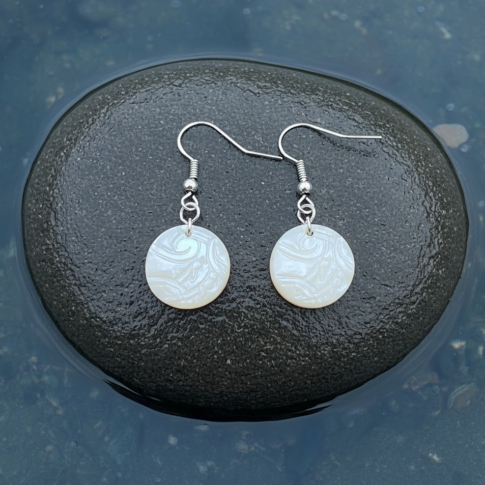 Witte parelmoeren oorbellen met gravering en sterling zilver 925 liggend op steen in water | White Round Shell