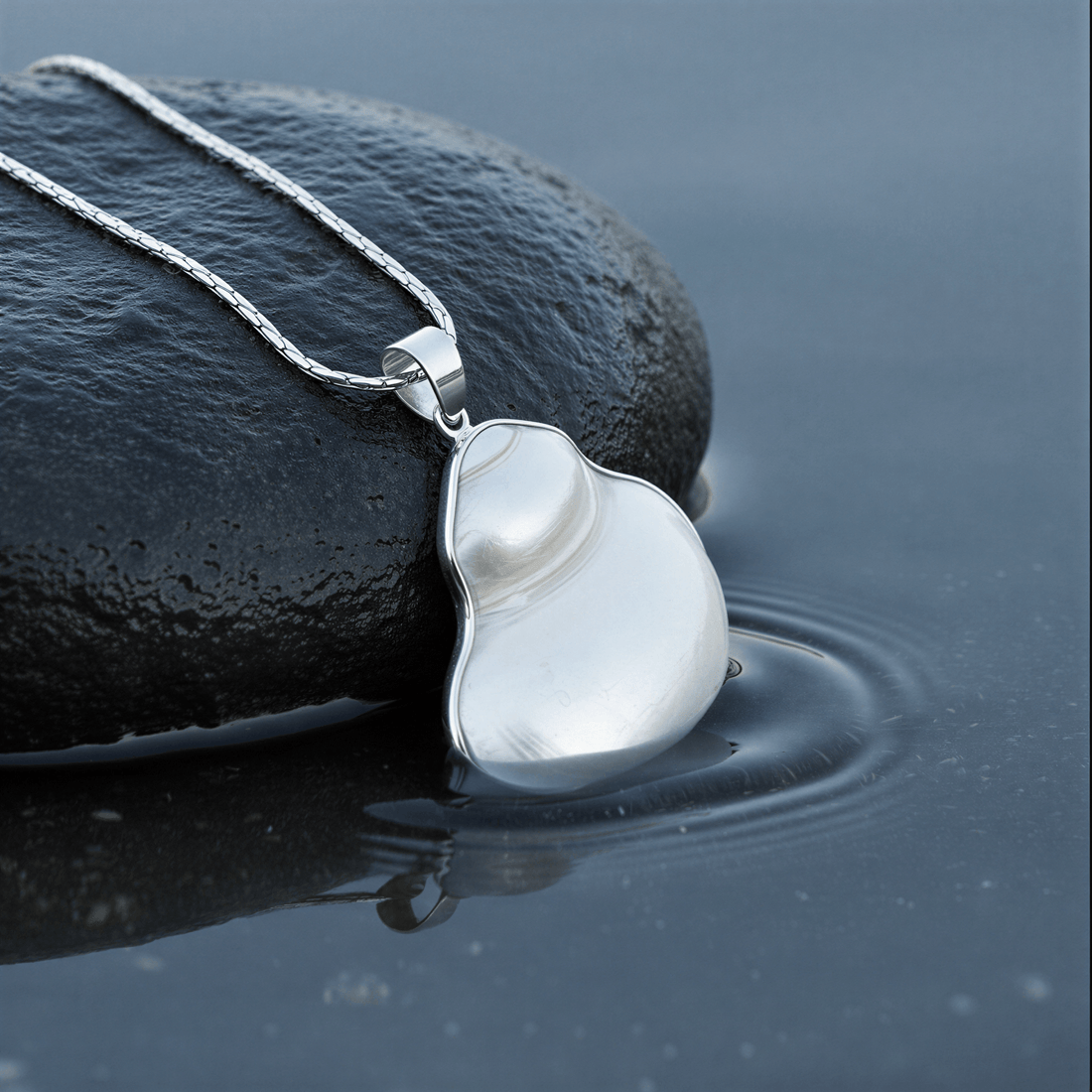 Witte schelpen ketting met zilver edelstaal liggend op steen in water | set Pearl White Turbo Shell