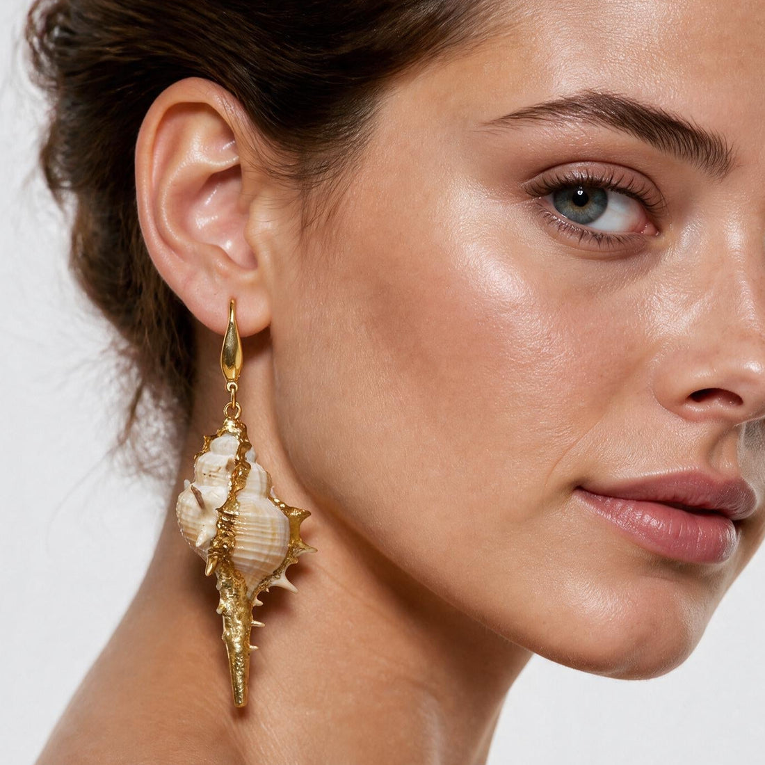 Lange schelpen oorbellen met witte schelp en goud edelstaal op model | Shell Cabrit Gold
