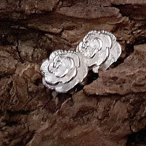 Verzilverde oorknoppen in de vorm van een bloem liggend op hout | Silver Flower