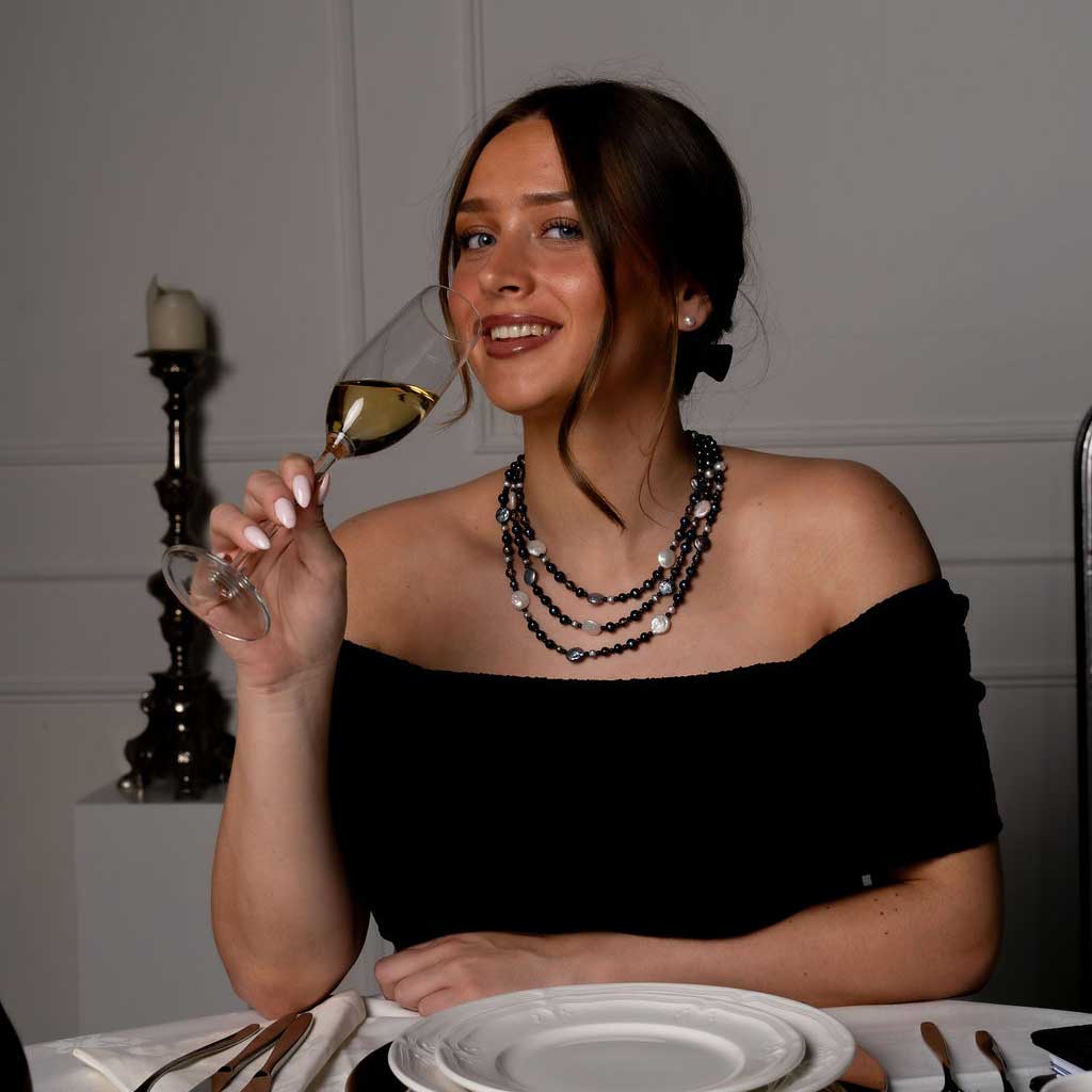 Zoetwater parelketting met witte, blauwe, grijze en bruine parels en rookkwarts in 3 rijen met model aan tafel | Claudia