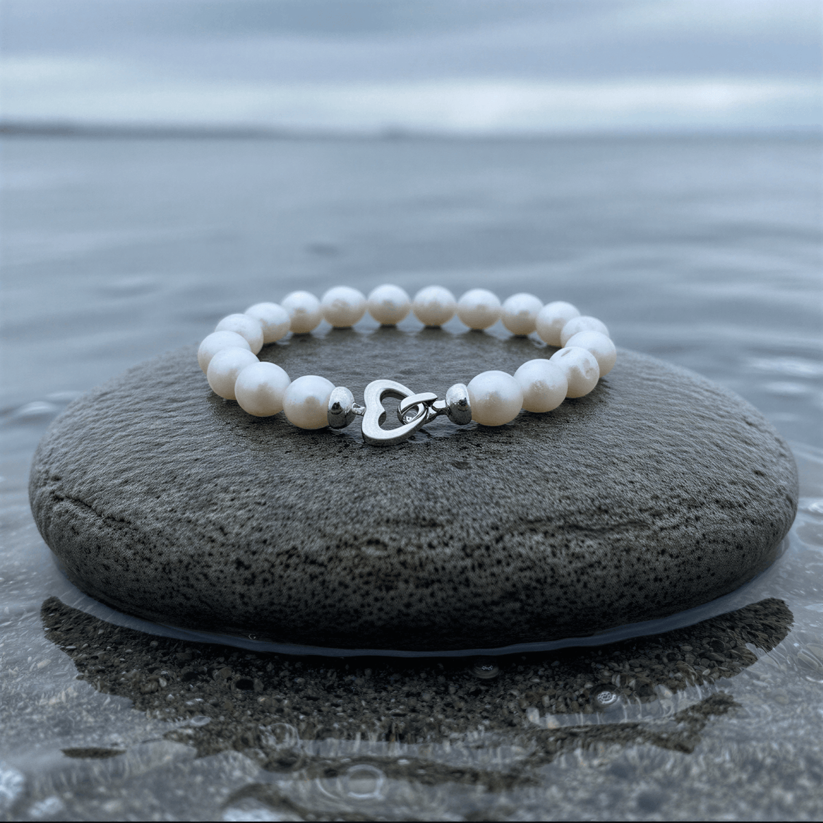 Handgeknoopt parel armband met witte parels liggend op steen met slotje voren | Parel armband Big Round pearl