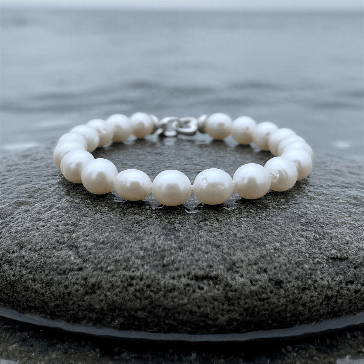 Handgeknoopt parel armband met witte parels liggend op steen | Parel armband Big Round pearl