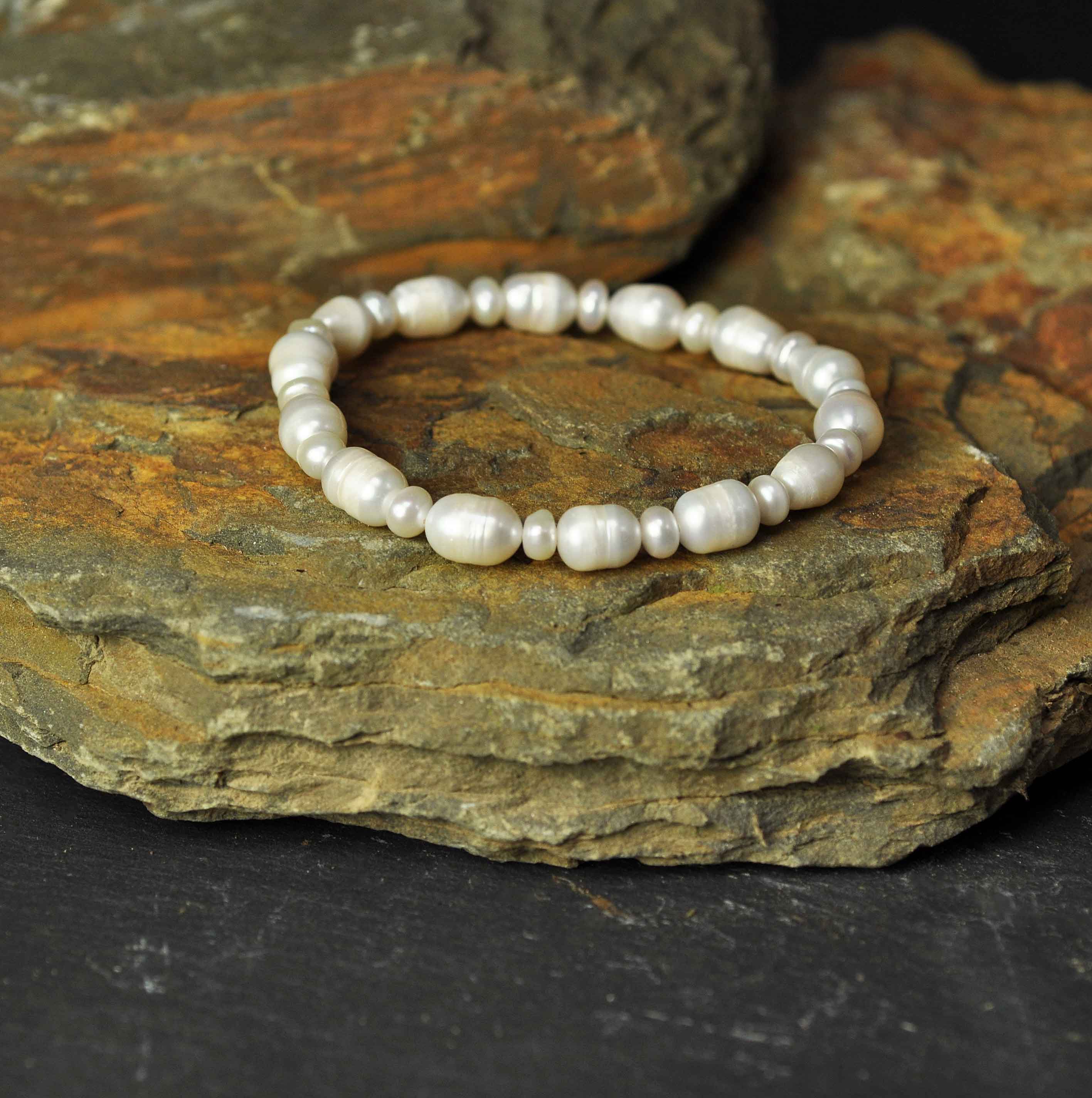 Wit elastisch zoetwater parel armband liggend op steen zijaanzicht | Big and Small