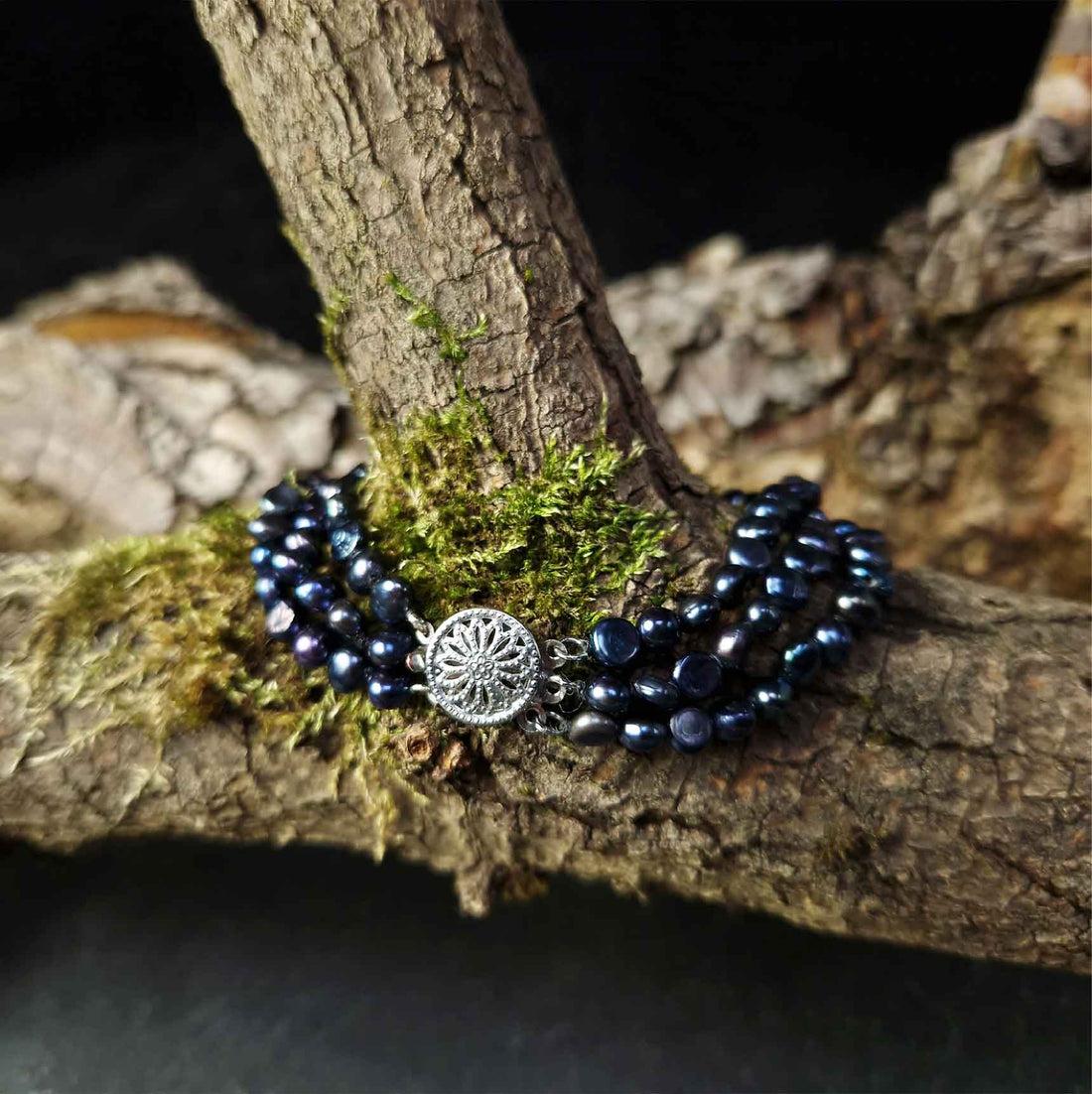 Zoetwater parel armband met 3 rijen blauw zwarte parels liggend op tak | Black Three Baroque Pearl