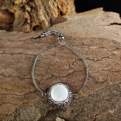 Wit zoetwater parel schuif armband met stras steentjes en edelstaal liggend op hout | Bright Minimal Silver Coin