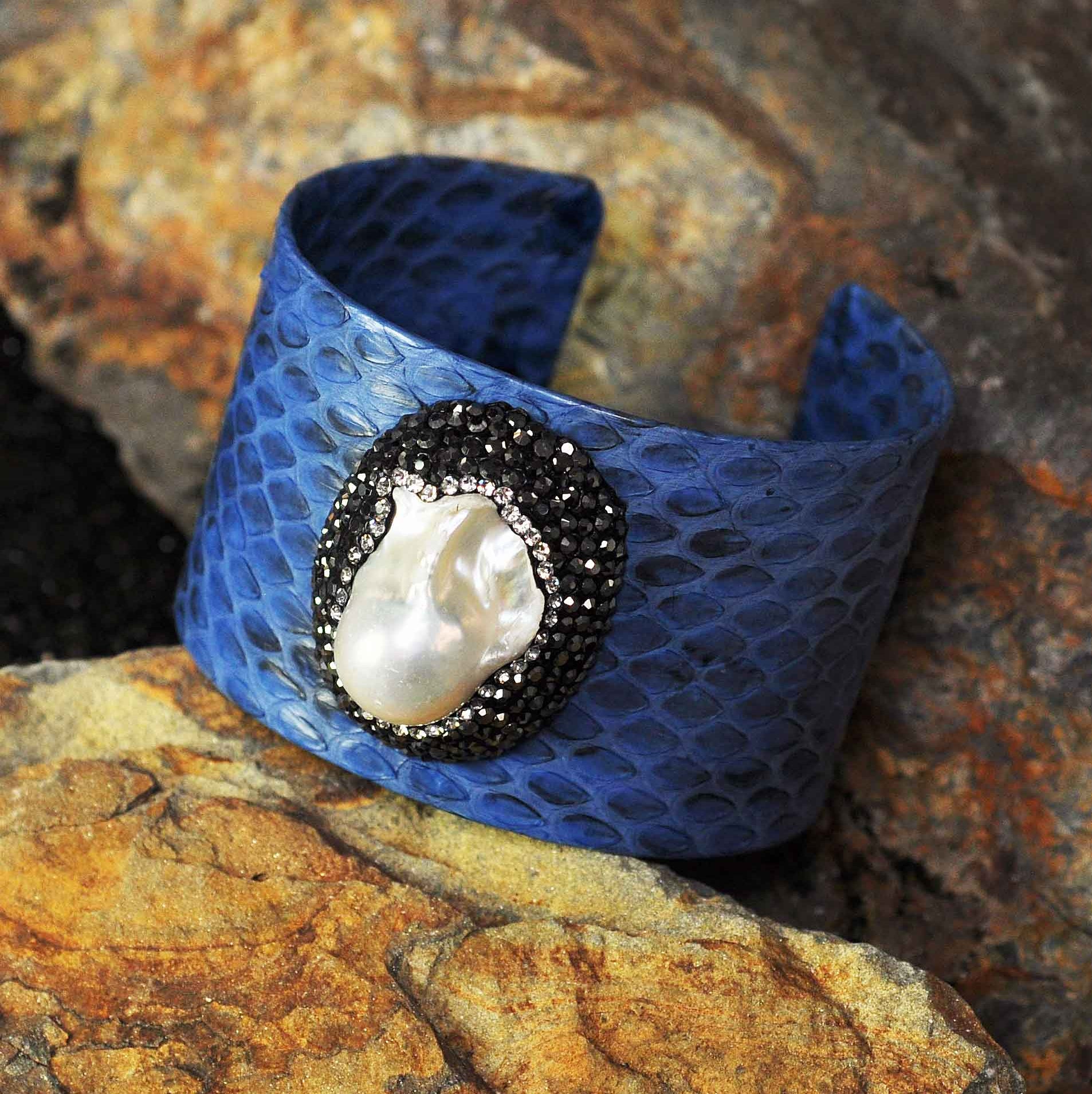 Zoetwater parel armband met witte parel, stras steentjes en blauw leer liggend op steen | Bright One Big Pearl Blue Leather