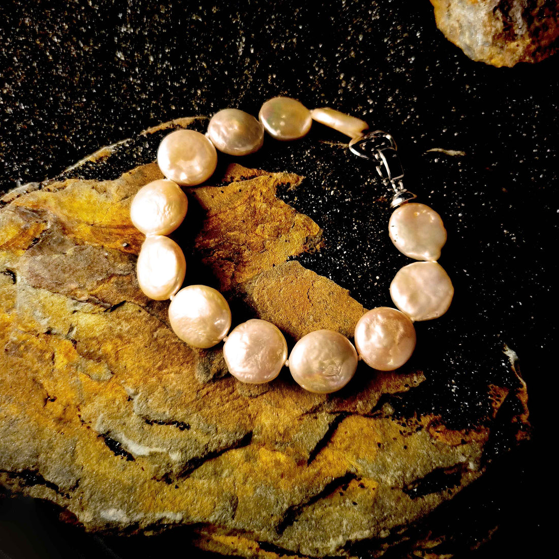 Zoetwater parel armband met zalm kleurige coin parels liggend op steen | Coin Peach