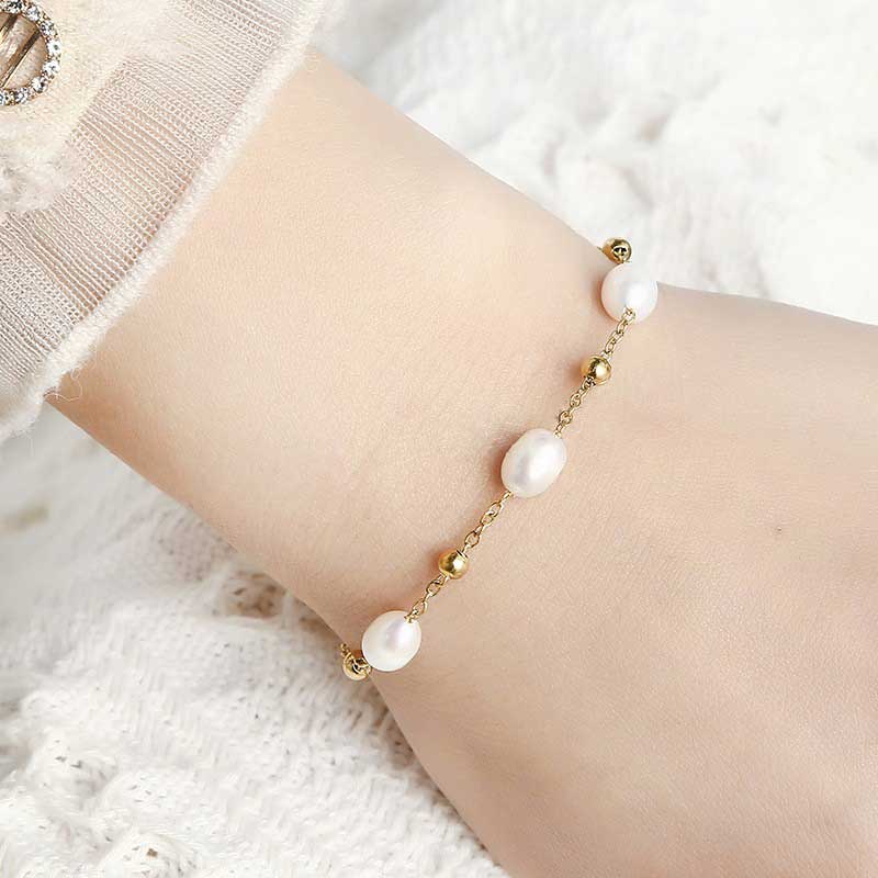 Wit zoetwater parel armband met goud edelstaal om pols | Parel armband Eline Goud
