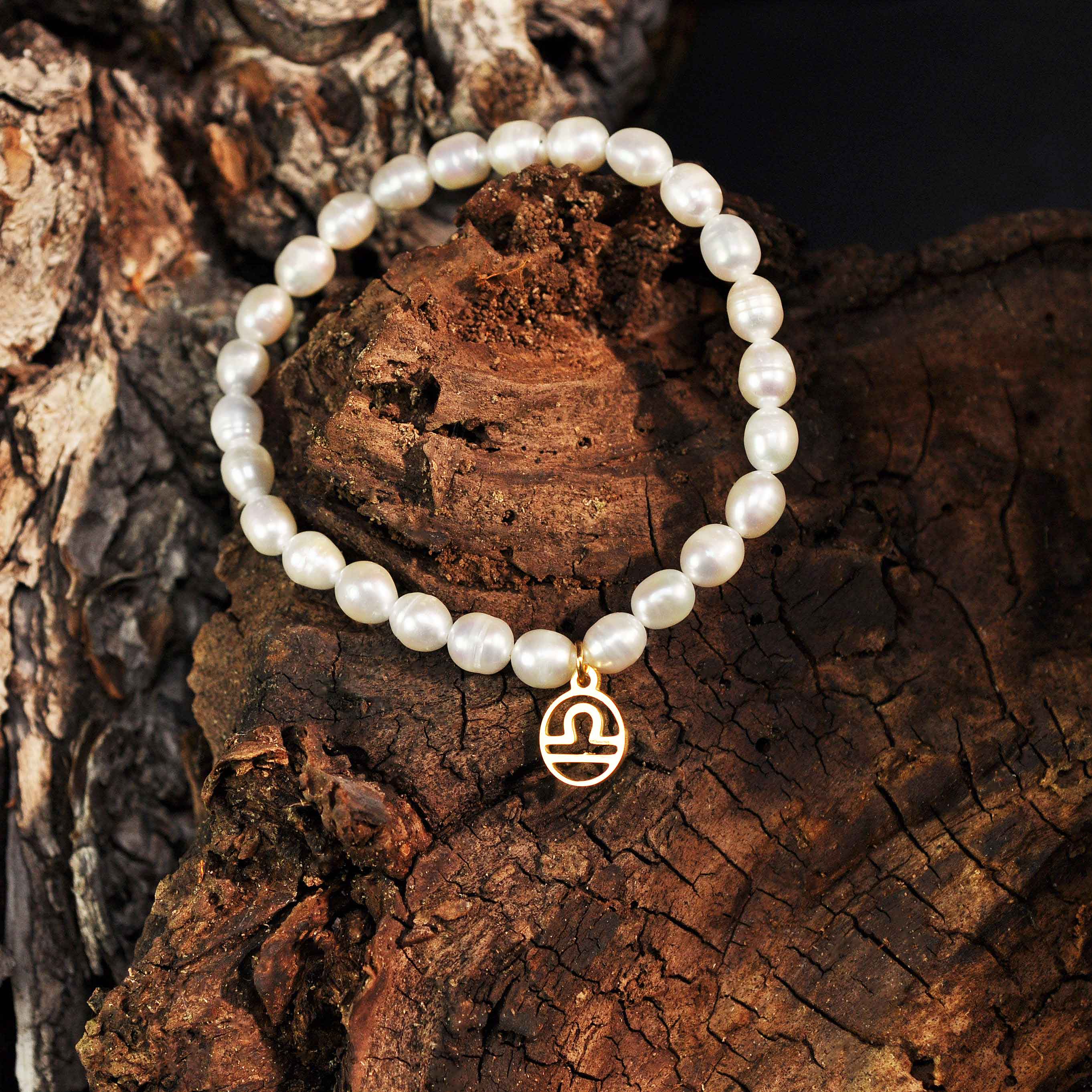 Wit zoetwater parel armband met goud edelstalen symbool van sterrenbeeld Weegschaal hangend aan schors | Armband Gouden Sterrenbeeld Weegschaal