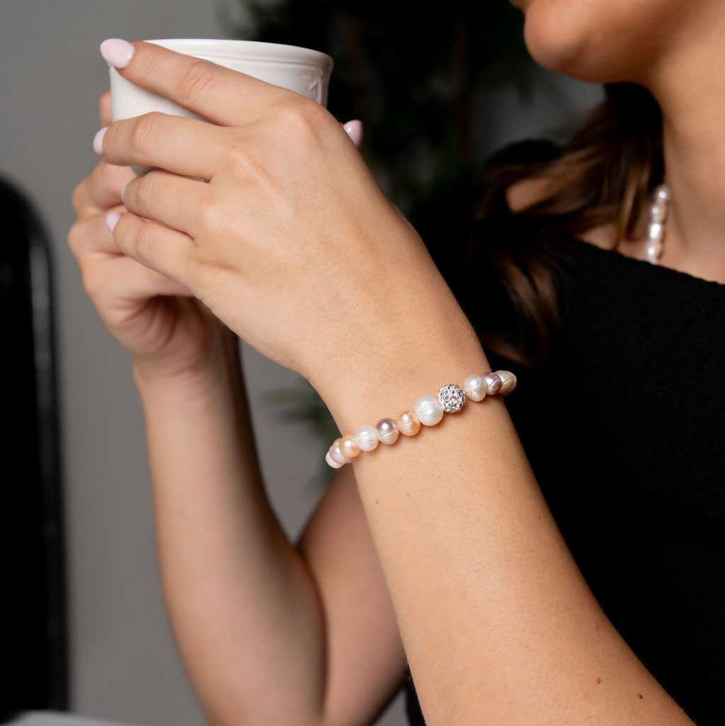 Zoetwater parel armband met wit, zalm, roze parels en stras steentjes, elastisch, op model, detail | Maxima Soft Colors
