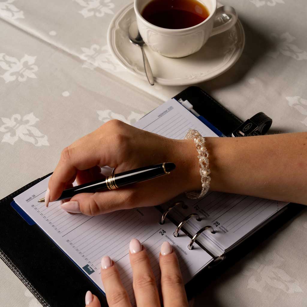 Wit zoetwater parel armband met beige kristal op model met agenda | Pearl Crystal Clear