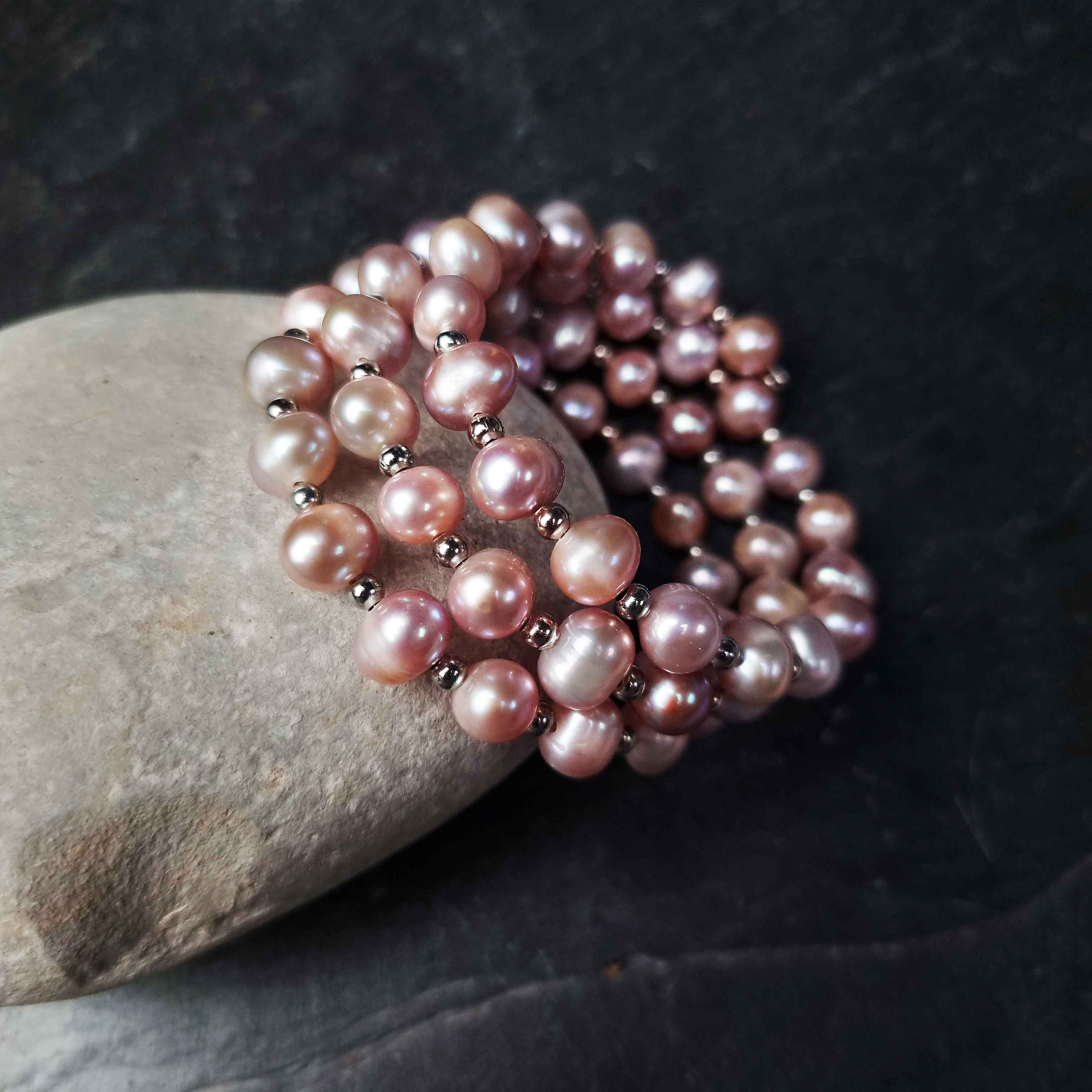 Roze zoetwater parel wikkelarmband liggend tegen kei | Pink Pearl Wrap